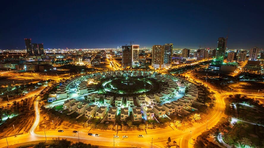 Scenic view of Jumeirah Village Circle with modern apartments and Dubai skyline in the background.